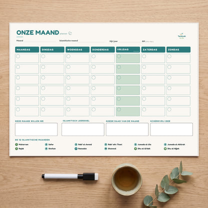 Onze Maand magneetplanner A3 op tafel met marker en een kop thee