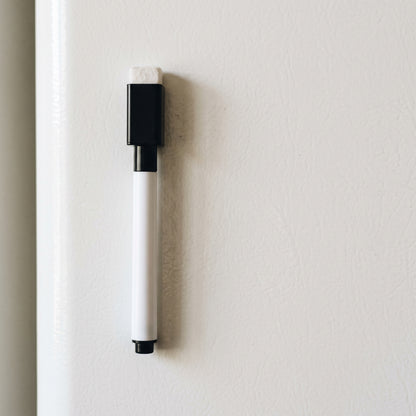 Magnetische whiteboardmarker hangt met de dop aan de koelkast